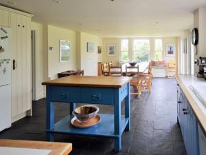 a kitchen with a blue island with a bowl on it at Downedge in Brading +40 photos