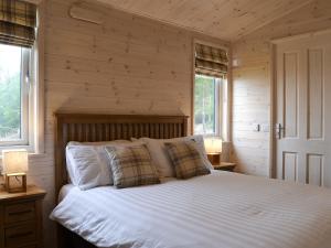 a bedroom with a bed with white sheets and pillows at Ben Klibreck in Kinloss