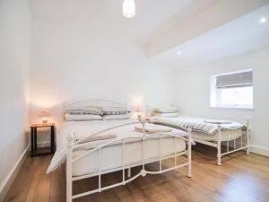 a white bedroom with two beds and a window at Cottage 6 - Ukc3183 in York