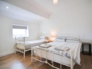 a white bedroom with two beds and a window at Cottage 6 - Ukc3183 in York