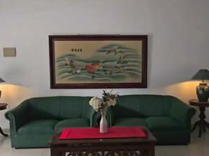 a living room with a green couch and a table at Dekuningan Executive in Jakarta