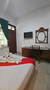 a bedroom with a bed and a desk and a television at Dekuningan Executive in Jakarta