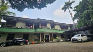 two cars parked in front of a building at Dekuningan Executive in Jakarta