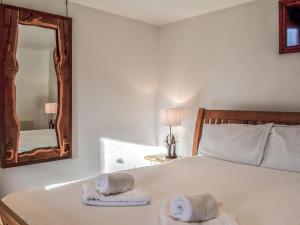 a bedroom with a bed with towels and a mirror at Anne's Cottage - Uk7782 in Newton Stewart