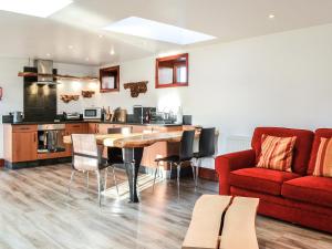 a living room with a table and a red couch at Anne's Cottage - Uk7782 in Newton Stewart