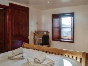 a room with a bed and a window and a chair at Anne's Cottage - Uk7782 in Newton Stewart +3 photos