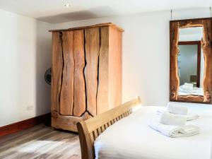 a bedroom with a wooden headboard and a mirror at Anne's Cottage - Uk7782 in Newton Stewart