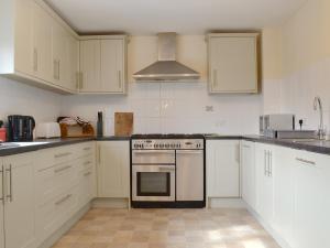 a kitchen with white cabinets and a stove top oven at The Walton - Ukc3232 in Onibury