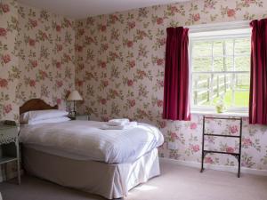a bedroom with a bed and a window with red curtains at Marble Lodge - Uk7635 in Pitlochry