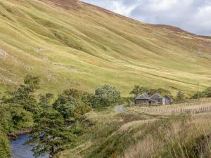 a house on the side of a hill next to a river at Marble Lodge - Uk7635 in Pitlochry