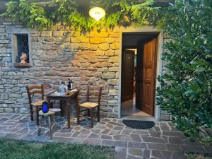 a table and chairs in front of a stone building at Agriturismo Corte Dei Mori in Brisighella