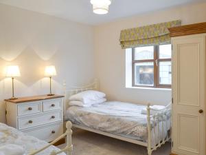 a bedroom with two beds and a window at The Corn Store in Malpas