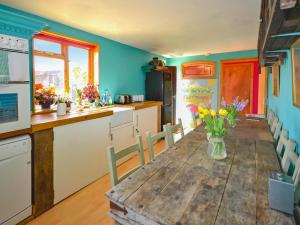 a kitchen with a wooden table with flowers on it at The Timber Store in Hardham