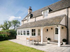 a house with a table and chairs on a patio at East Balnacraig in Banchory