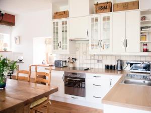 a kitchen with white cabinets and a wooden table at East Balnacraig in Banchory