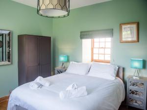 a bedroom with a white bed with towels on it at East Balnacraig in Banchory