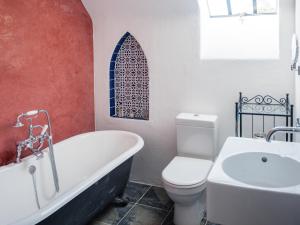 a bathroom with a tub and a toilet and a sink at East Balnacraig in Banchory