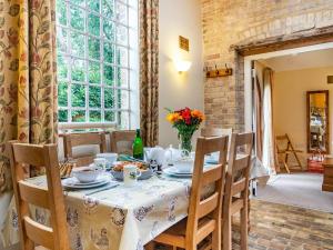 a dining room with a table and chairs and a window at Stearn Cottage-17917 in Langham