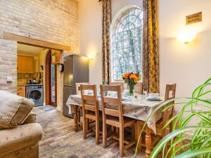 a kitchen and dining room with a table and chairs at Stearn Cottage-17917 in Langham