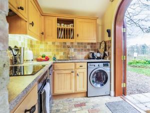 a kitchen with a washing machine in a kitchen at Stearn Cottage-17917 in Langham
