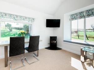 a living room with a table and chairs and a fireplace at The Byre in Kirkcudbright