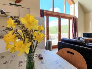 a vase of yellow flowers sitting on a table at The Byre - Uk7790 in Milton of Auchinhove