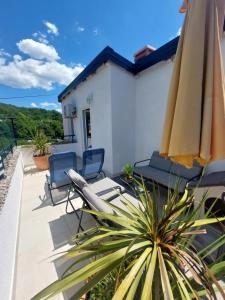 a patio with two chairs and an umbrella at Ester in Kastav