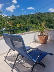 a blue chair sitting on a balcony with a plant at Ester in Kastav +4 photos