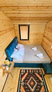 a small room with a bed in a cabin at Green Owl in Dedoplis Tskaro