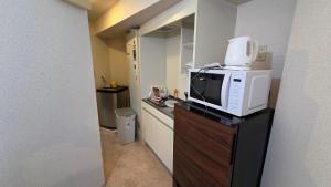 a kitchen with a microwave on top of a counter at MORI Apartment Near namba in Osaka