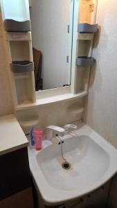 a bathroom with a white sink and a mirror at MORI Apartment Near namba in Osaka