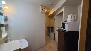 a bathroom with a microwave on top of a dresser at MORI Apartment Near namba in Osaka +2 photos
