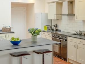a kitchen with a counter with a bowl of fruit at Ford Cottage in Banchory