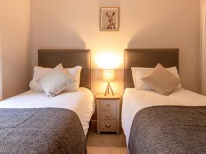 two beds sitting next to each other in a bedroom at Ford Cottage in Banchory +3 photos