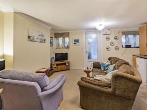 a living room with two couches and a tv at The Garden Flat in Torquay