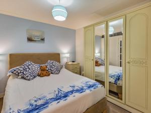 a teddy bear sitting on a bed in a bedroom at The Garden Flat in Torquay +8 photos