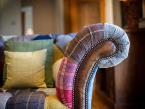 a sweater on the back of a couch with pillows at Edenville in Girthon