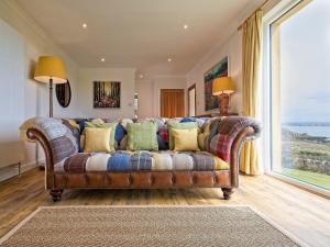 a couch in a living room with a large window at Edenville in Girthon