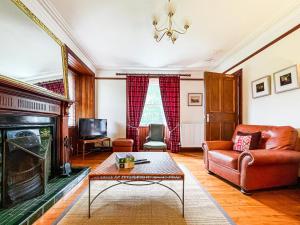a living room with a couch and a fireplace at Balloan Cottage-Uk7382 in Dornoch