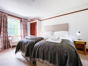 a bedroom with a bed with two towels on it at Balloan Cottage-Uk7382 in Dornoch