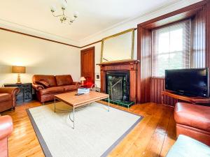 a living room with a couch and a fireplace at Balloan Cottage-Uk7382 in Dornoch