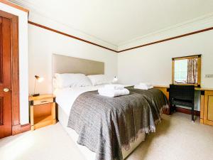 a bedroom with a bed with two towels on it at Balloan Cottage-Uk7382 in Dornoch +5 photos