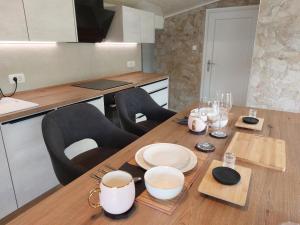 a kitchen with a wooden table with dishes on it at Ester in Kastav