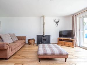 a living room with a couch and a tv at Delmhor No4 in Aviemore