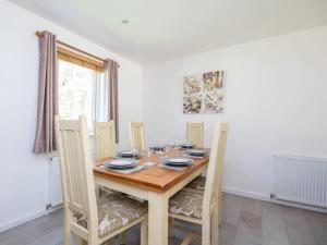 a dining room with a wooden table and chairs at Delmhor No4 in Aviemore