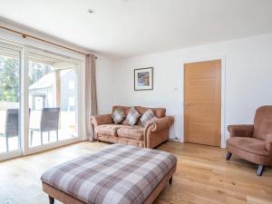 a living room with a couch and two chairs at Delmhor No4 in Aviemore
