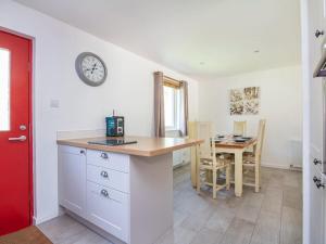 a kitchen with a table and a clock on the wall at Delmhor No4 in Aviemore +15 photos