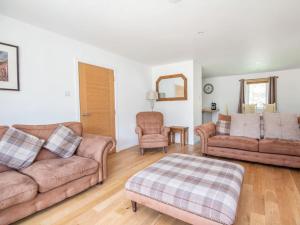 a living room with two couches and a ottoman at Delmhor No4 in Aviemore
