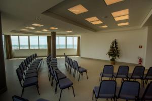 a room with a bunch of chairs and a christmas tree at Dunas Praia Hotel in Torres +50 photos