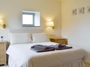 a bedroom with a bed with a towel on it at The Hayloft-W42941 in Burn